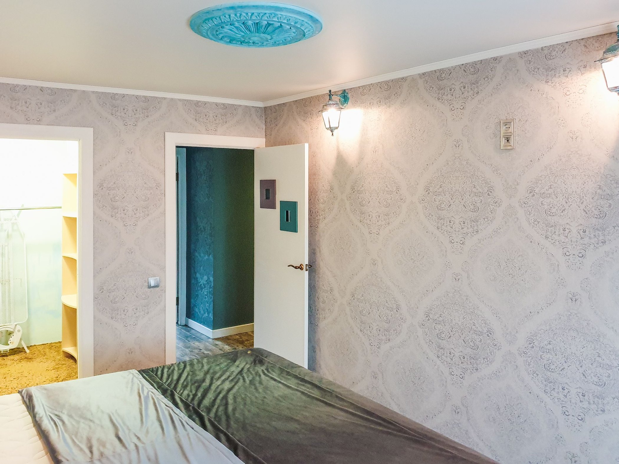 Pale textured damask wallpaper covering the walls around a bed